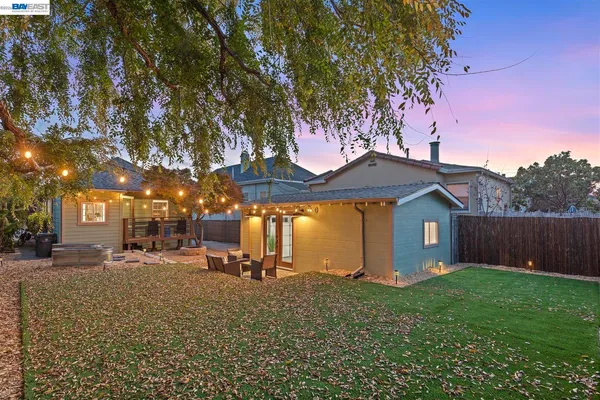 a view of backyard with wooden fence and large trees