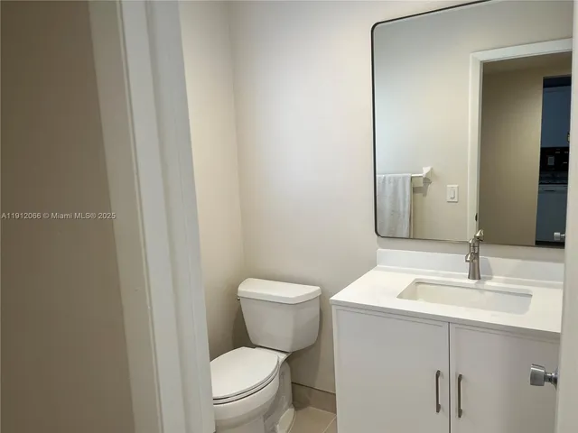 a bathroom with a toilet a sink and mirror