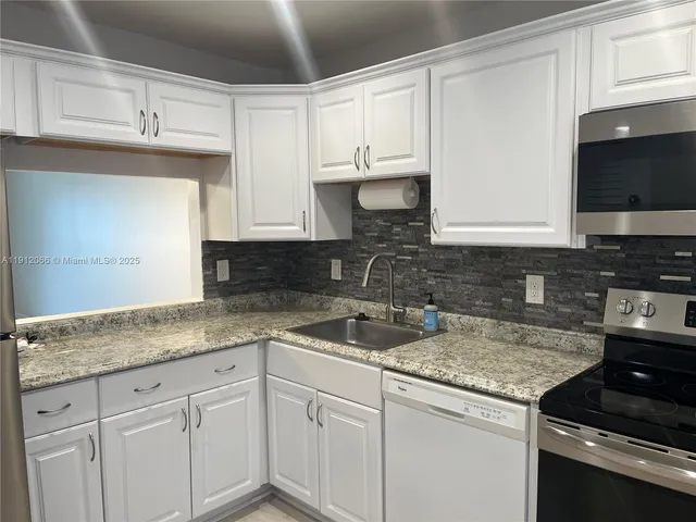 a kitchen with granite countertop a sink and a stove