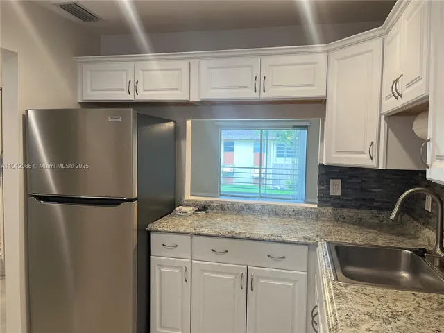 a white refrigerator freezer sitting inside of a kitchen