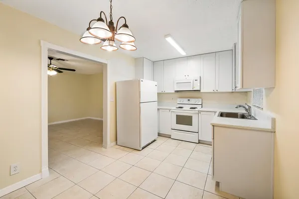 a kitchen with white cabinets and white appliances