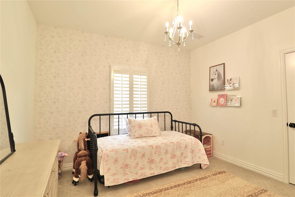 2610 Weetu Road Iowa Park, TX 76367 - Photo 17 of 35 a bedroom with a bed and a chandelier
