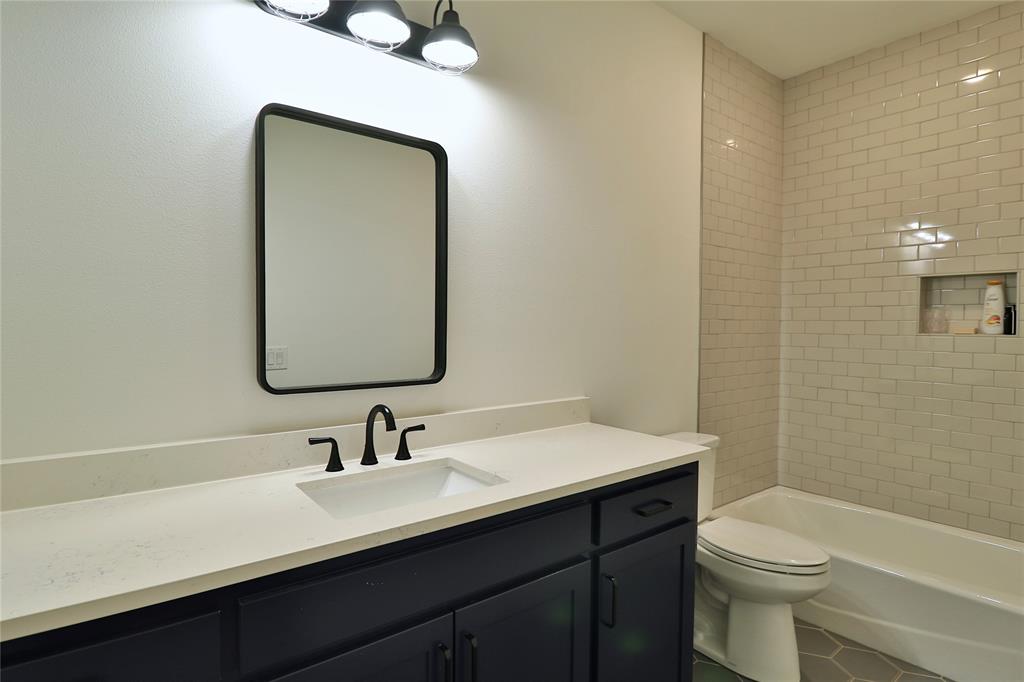 2610 Weetu Road Iowa Park, TX 76367 - Photo 19 of 35 a bathroom with a double vanity sink toilet and a mirror