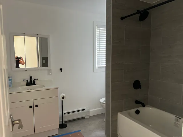 a bathroom with a tub a sink and mirror