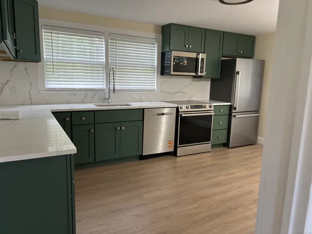 a kitchen with stainless steel appliances granite countertop a sink stove and refrigerator