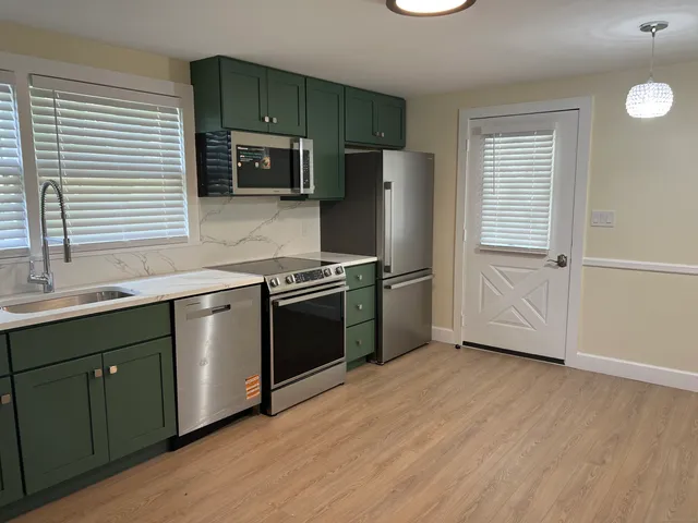a kitchen with granite countertop a refrigerator and a sink