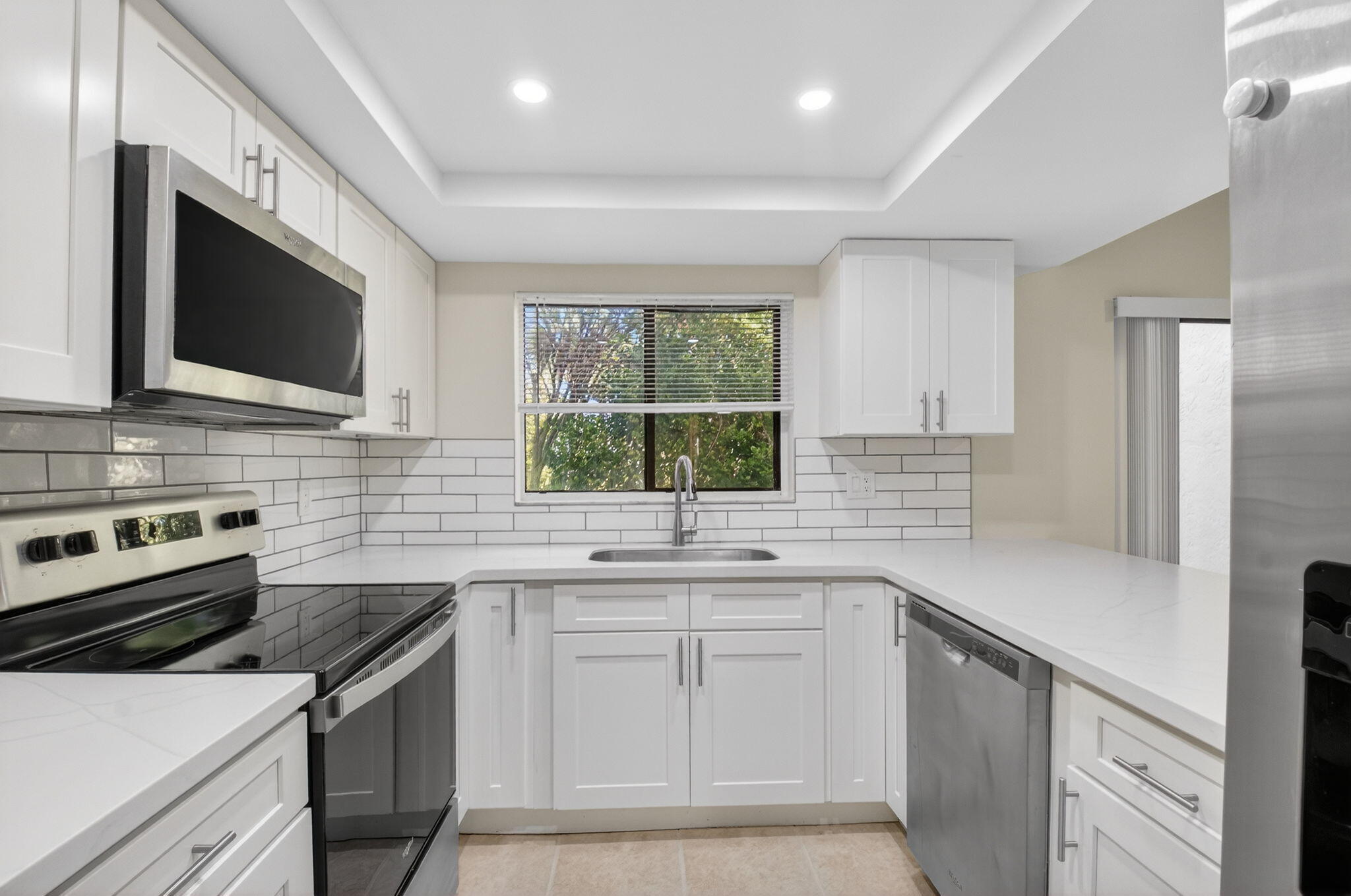 3143 Kingswood Terrace, Unit 3143 Boca Raton, FL 33431 - Photo 12 of 66 a kitchen with a sink stove and microwave