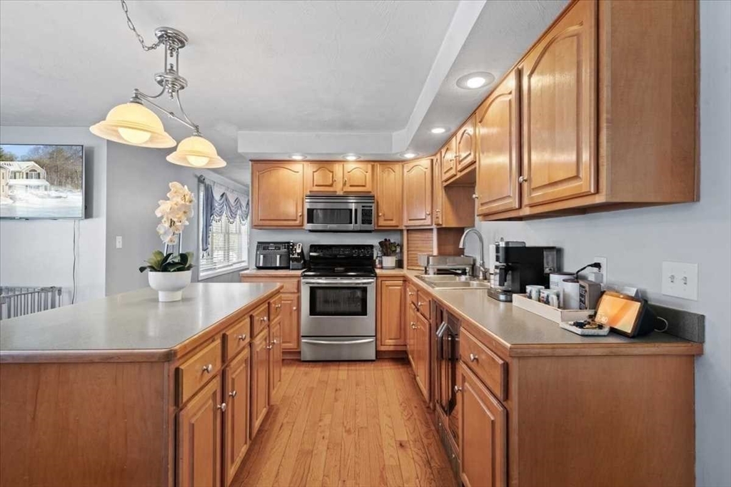 8 Wamsutta Ridge Road Charlton, MA 01507 - Photo 10 of 38 a kitchen with stainless steel appliances granite countertop a stove a sink dishwasher and a refrigerator with wooden floor