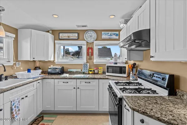 a kitchen with stainless steel appliances a stove a sink and a microwave