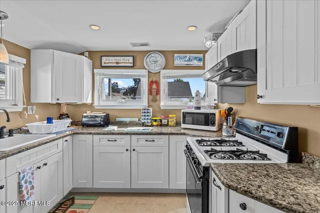 a kitchen with stainless steel appliances a stove a sink and a microwave