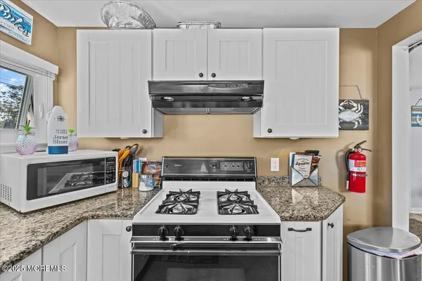 a kitchen with granite countertop a stove and a sink