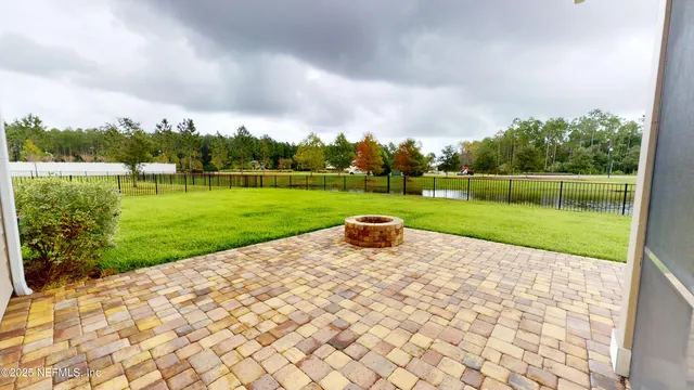 a view of a park with large trees and a wooden fence