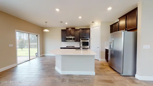 a kitchen with stainless steel appliances a refrigerator and a stove top oven