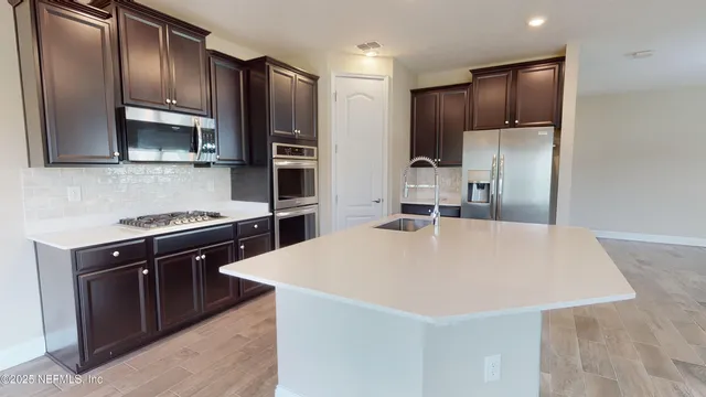a kitchen with stainless steel appliances a refrigerator and a stove top oven