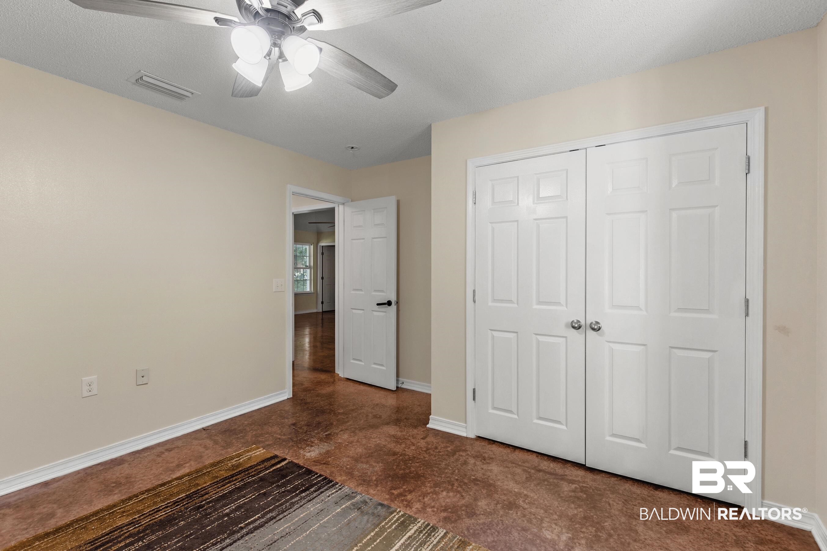 36087 Byrd Road Stapleton, AL 36578 - Photo 13 of 27 Unfurnished bedroom featuring a closet, ceiling fan, and a textured ceiling