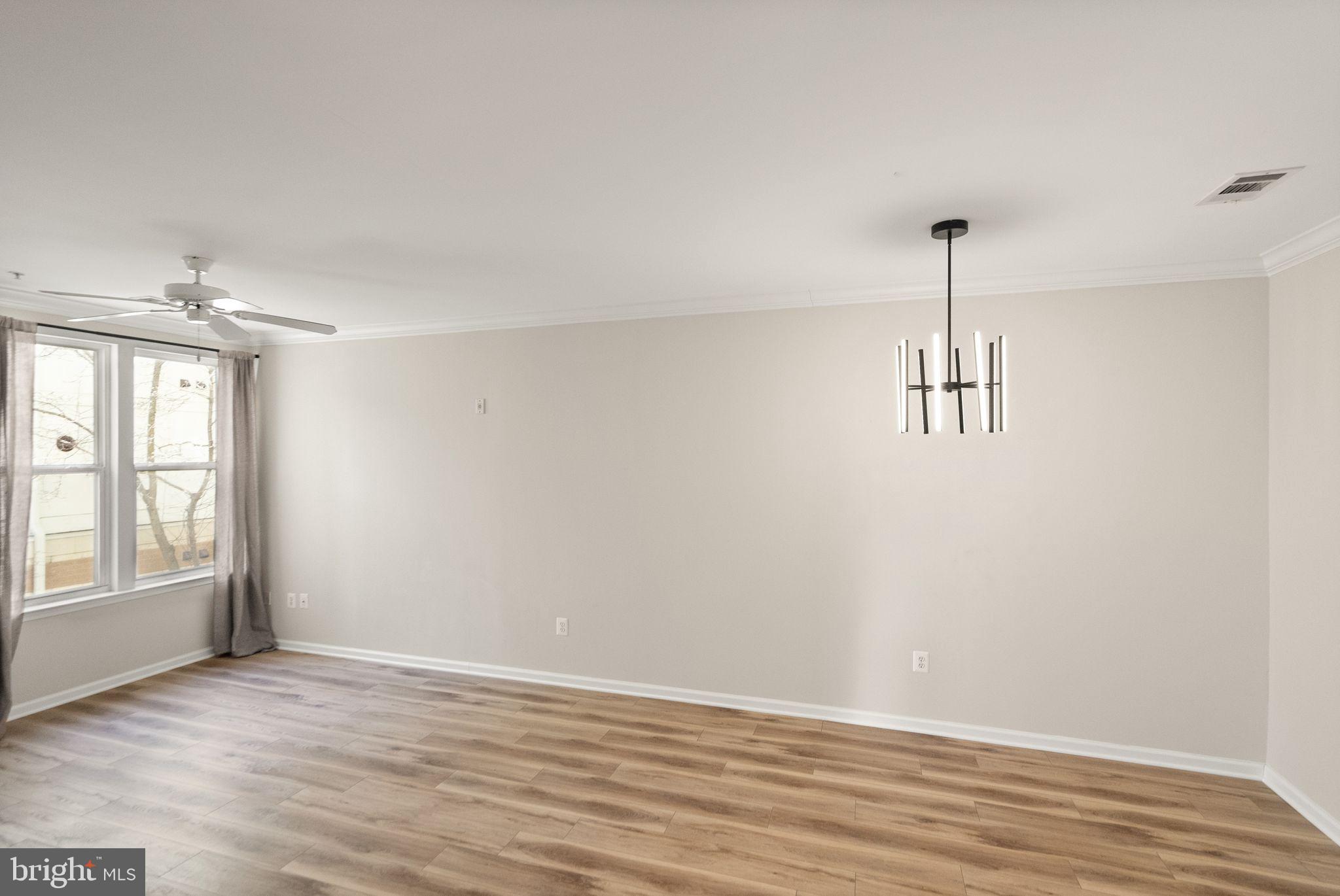 12001 Market Street, Unit 206 Reston, VA 20190 - Photo 11 of 25 a view of an empty room with window and wooden floor