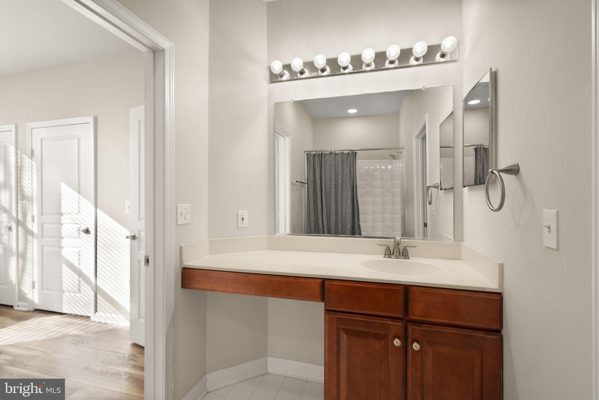 12001 Market Street, Unit 206 Reston, VA 20190 - Photo 21 of 25 a bathroom with a sink and a mirror