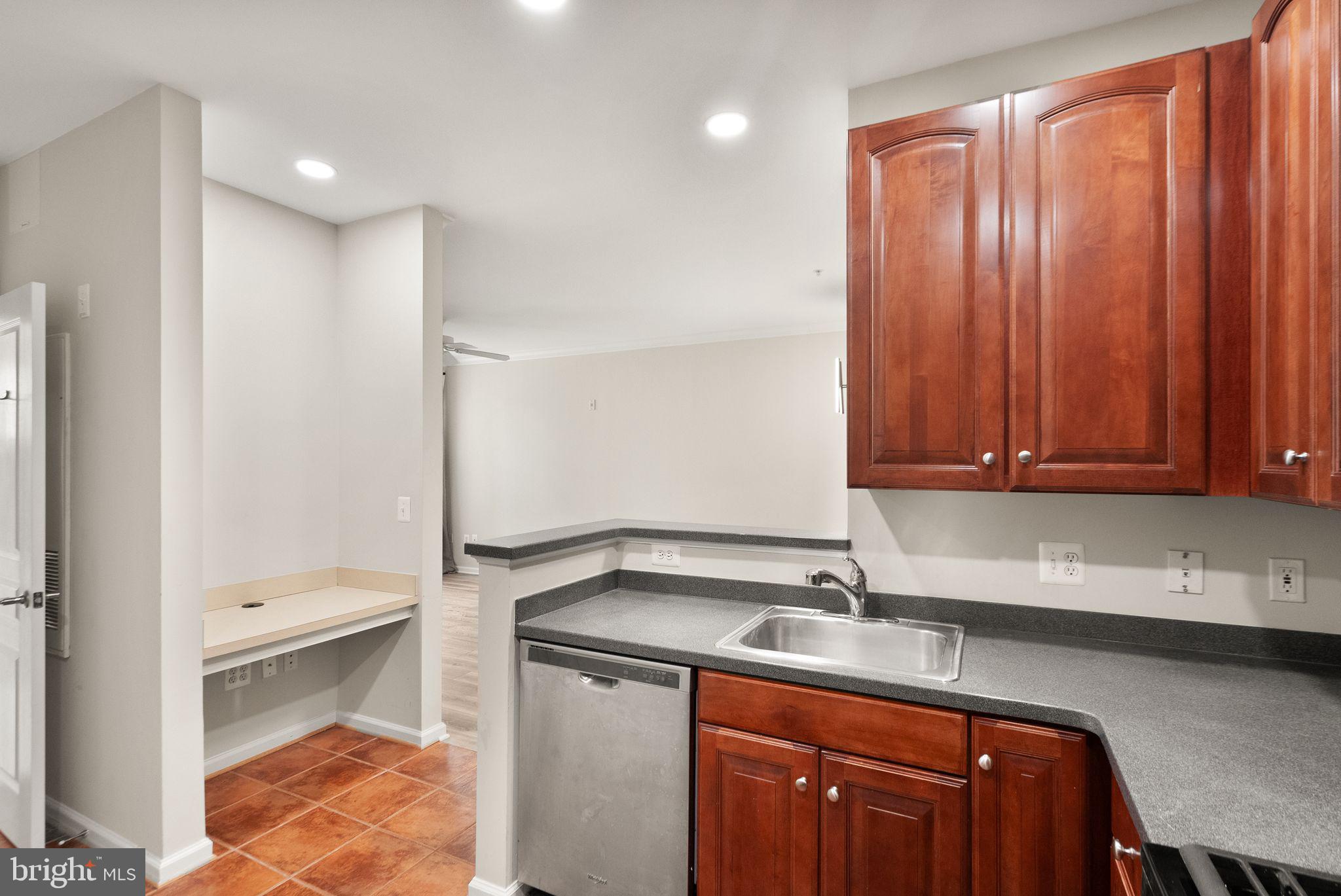 12001 Market Street, Unit 206 Reston, VA 20190 - Photo 10 of 25 a kitchen with a sink a stove and cabinets