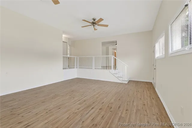 a view of a livingroom with wooden floor and a ceiling fan