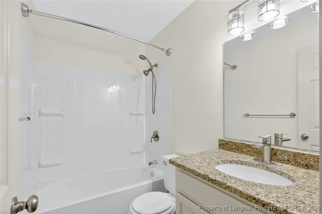 a bathroom with a granite countertop sink toilet a mirror and shower