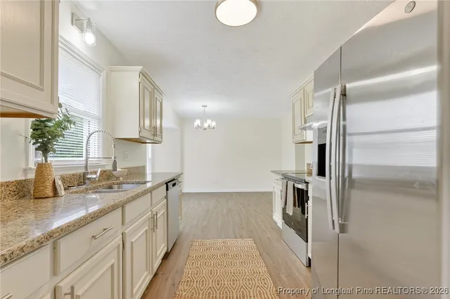 a kitchen with granite countertop a refrigerator and a sink