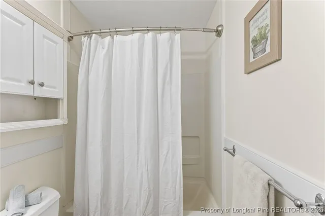 a bathroom with a shower curtain and a window