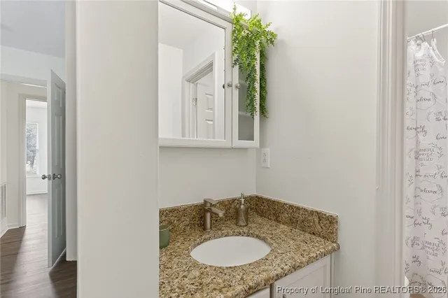 a bathroom with a granite countertop sink and a mirror