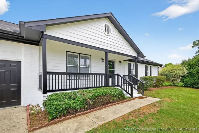 a front view of a house with a garden and deck