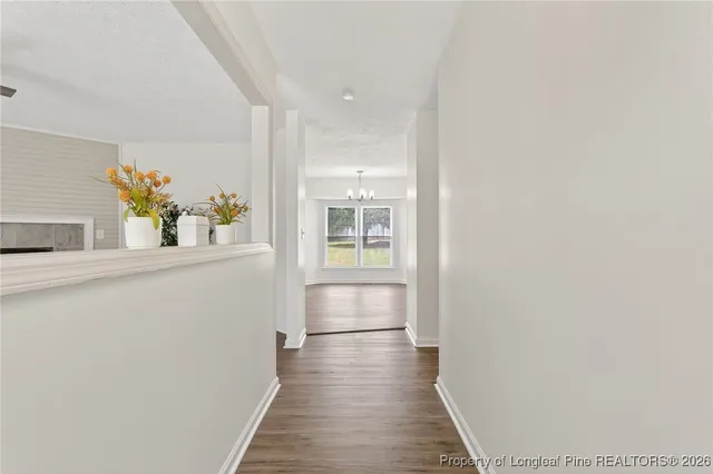 a hallway with wooden floor and table