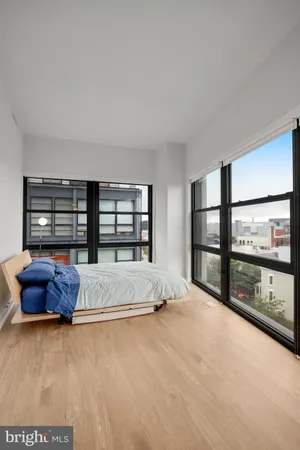 a bedroom with a bed and a flat tv screen on dresser