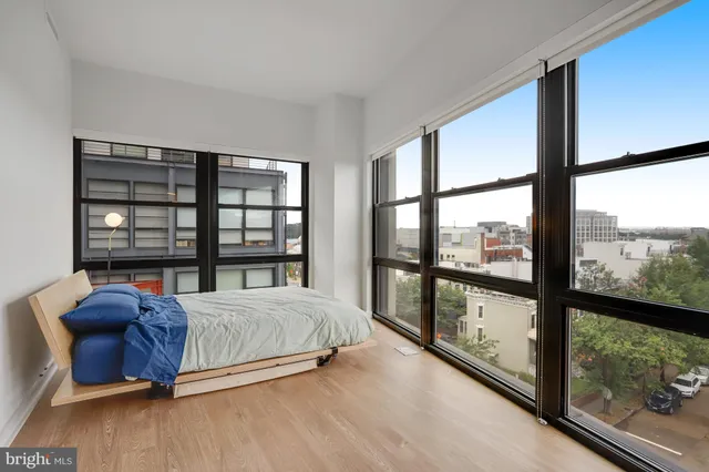a bedroom with a large bed and a flat tv screen on dresser