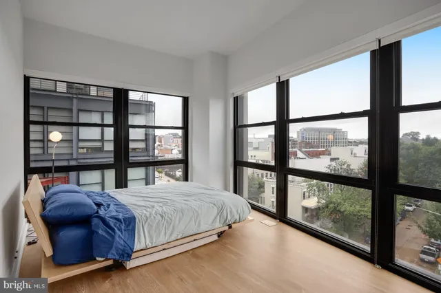 a bedroom with a large window and a bed