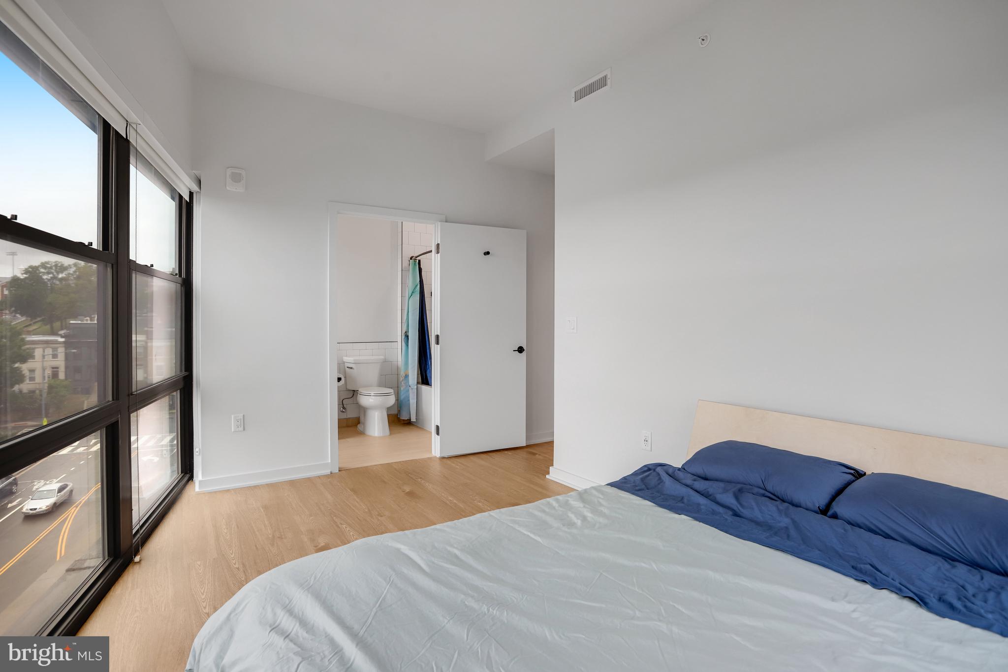 1625 Eckington Place Northeast, Unit 604 Washington, DC 20002 - Photo 20 of 68 a bedroom with a large bed and a flat tv screen on dresser
