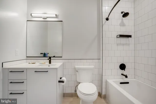 a living room with furniture and a dining table with large windows