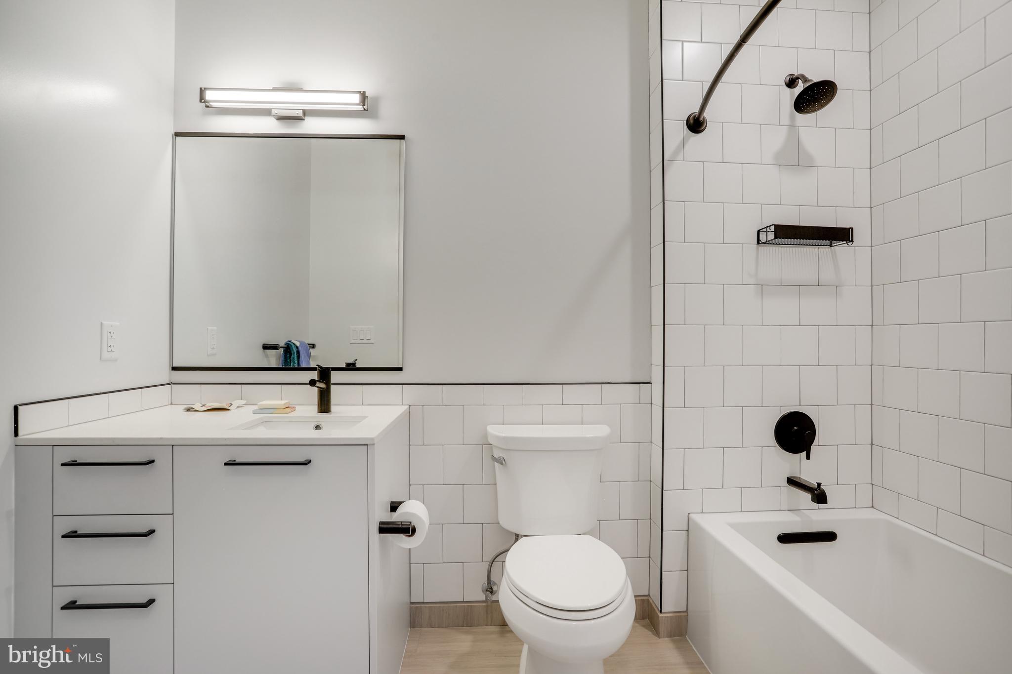 1625 Eckington Place Northeast, Unit 604 Washington, DC 20002 - Photo 28 of 68 a bathroom with a sink a toilet and shower