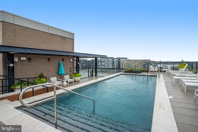 a dining hall with stainless steel appliances granite countertop a dining table chairs and stove top oven