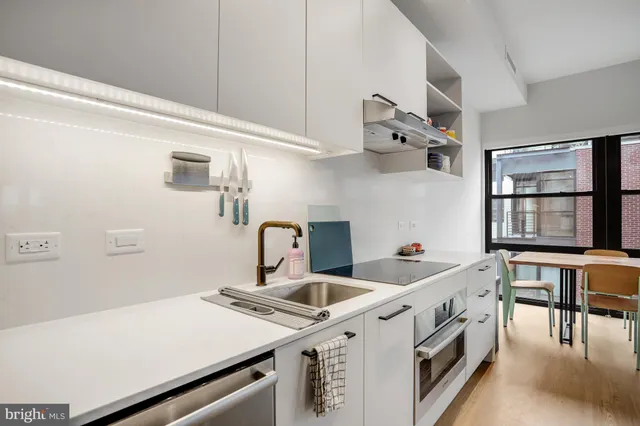 a kitchen with a refrigerator and white cabinets