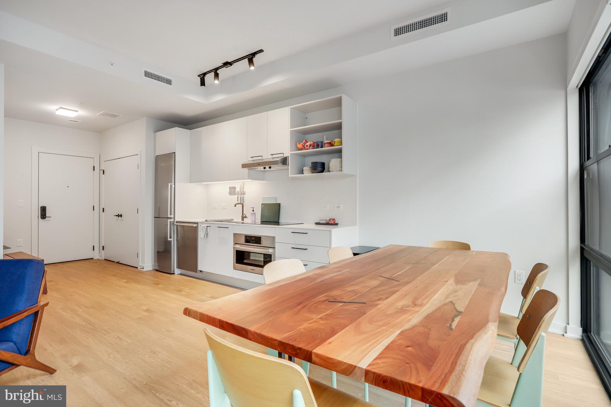 1625 Eckington Place Northeast, Unit 604 Washington, DC 20002 - Photo 9 of 68 a bed room with a bed and a kitchen