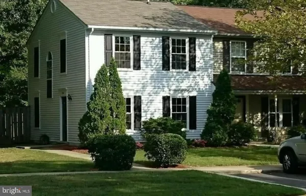 a view of a house with a yard and potted plants