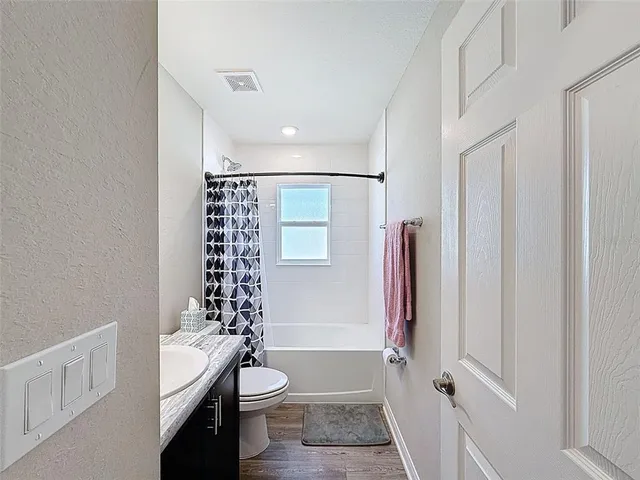 a bathroom with a sink a toilet a tub and shower