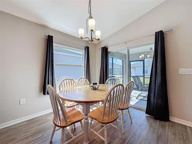 a dining room with furniture a chandelier and wooden floor