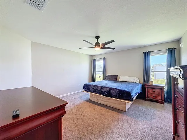 a spacious bedroom with a bed and a window