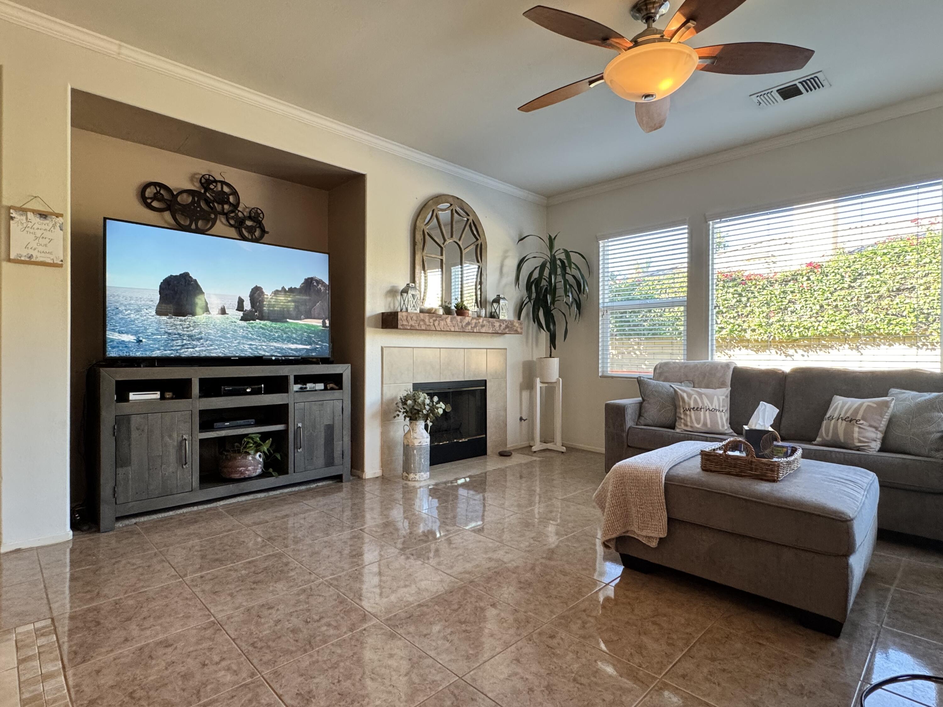 82774 Matthau Drive Indio, CA 92201 - Photo 2 of 44 a living room with furniture a fireplace and a large window