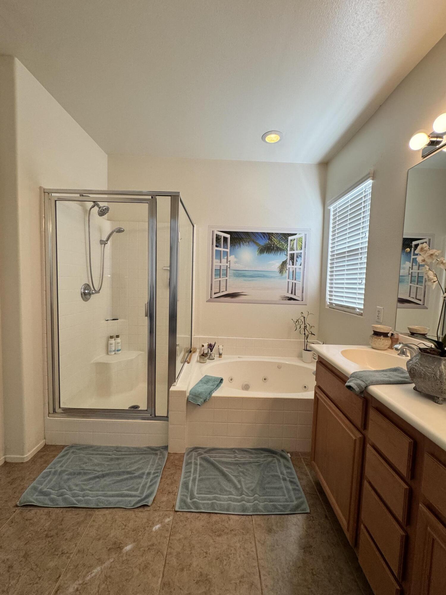 82774 Matthau Drive Indio, CA 92201 - Photo 5 of 44 a spacious bathroom with a granite countertop sink a mirror and a bathtub