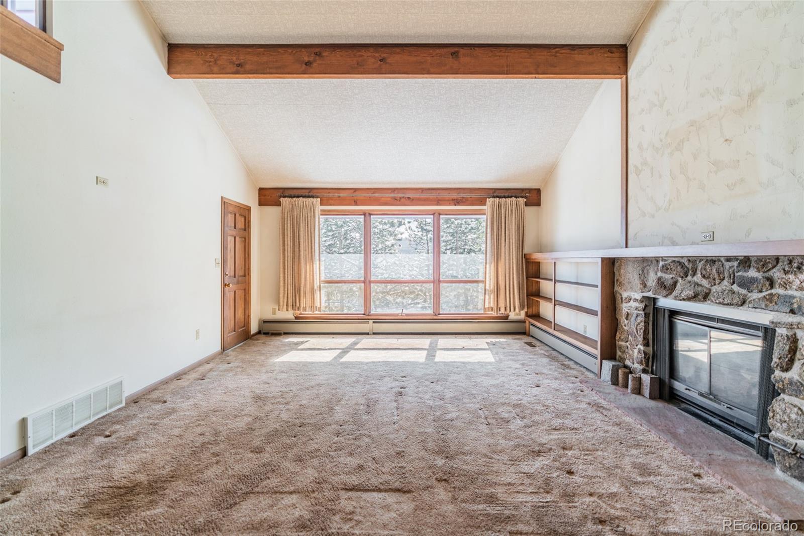 1189 Aspen Drive Evergreen, CO 80439 - Photo 11 of 37 a view of an empty room with a fireplace and a window