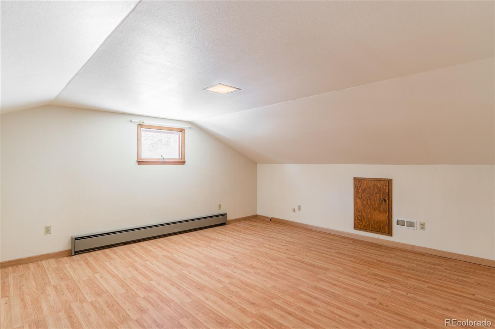 1189 Aspen Drive Evergreen, CO 80439 - Photo 20 of 37 an empty room with wooden floor and windows