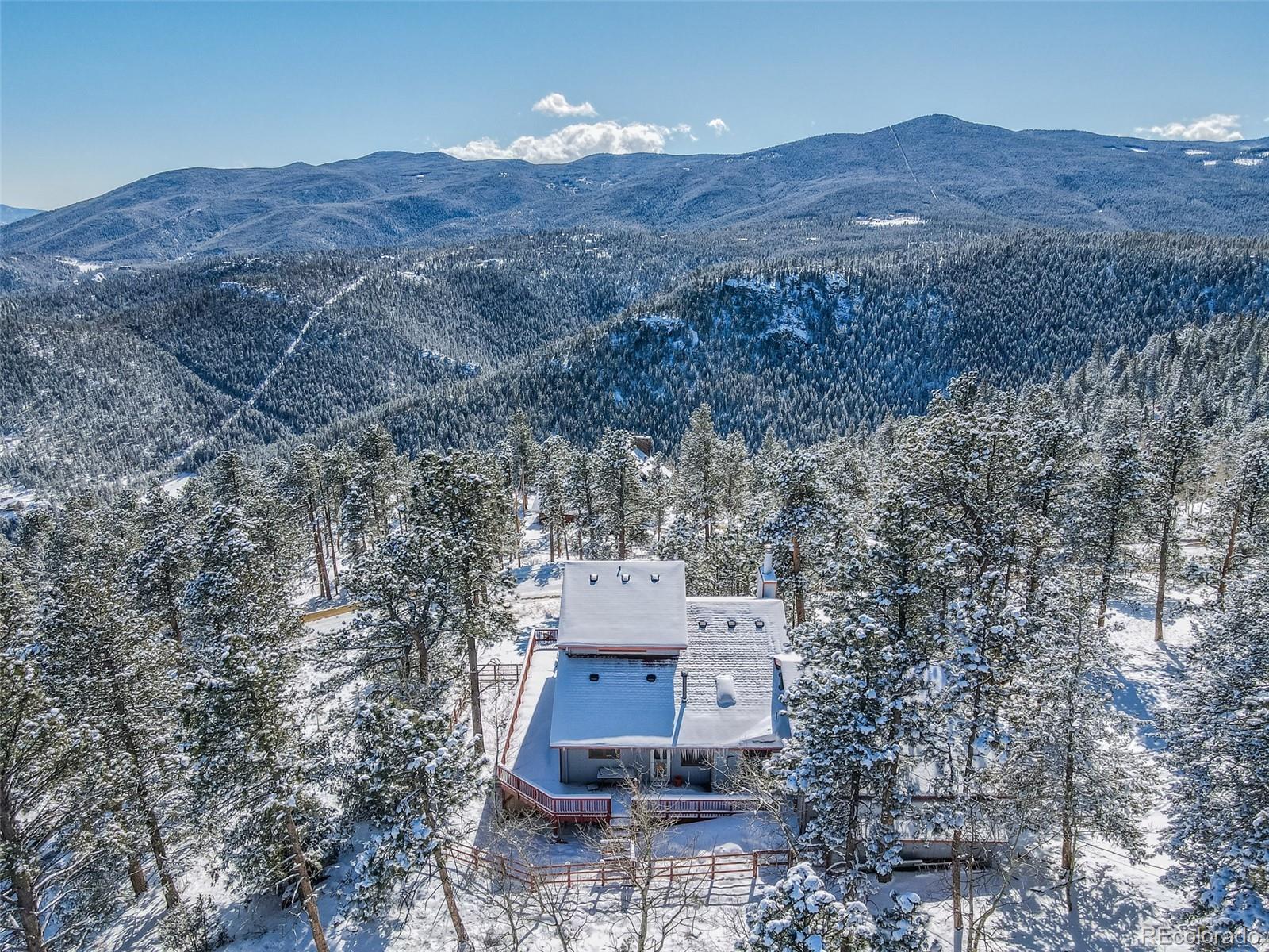 1189 Aspen Drive Evergreen, CO 80439 - Photo 2 of 37 a view of a house with a field and a mountain view