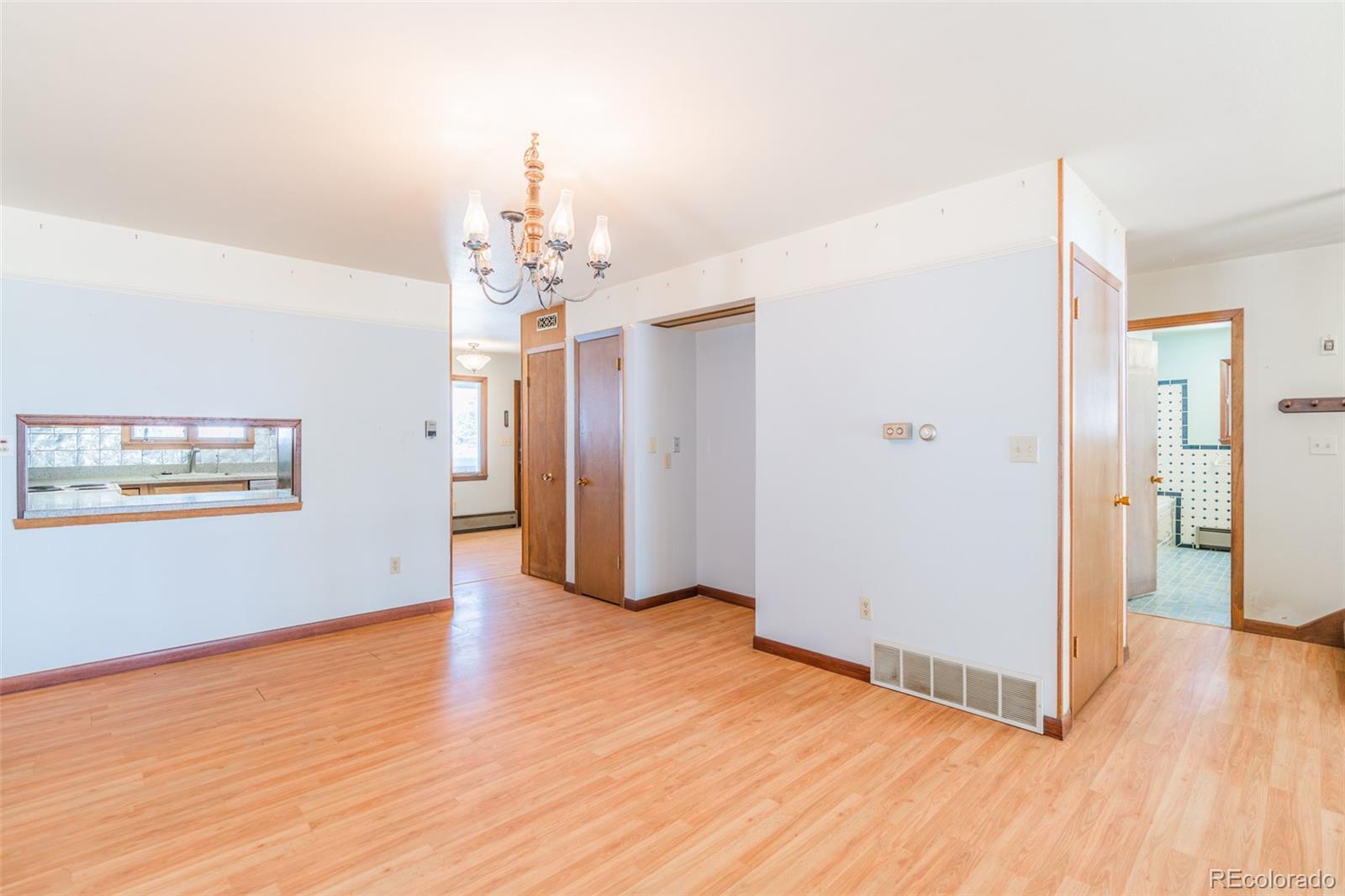 1189 Aspen Drive Evergreen, CO 80439 - Photo 7 of 37 a view of a hallway with wooden floor and a chandelier