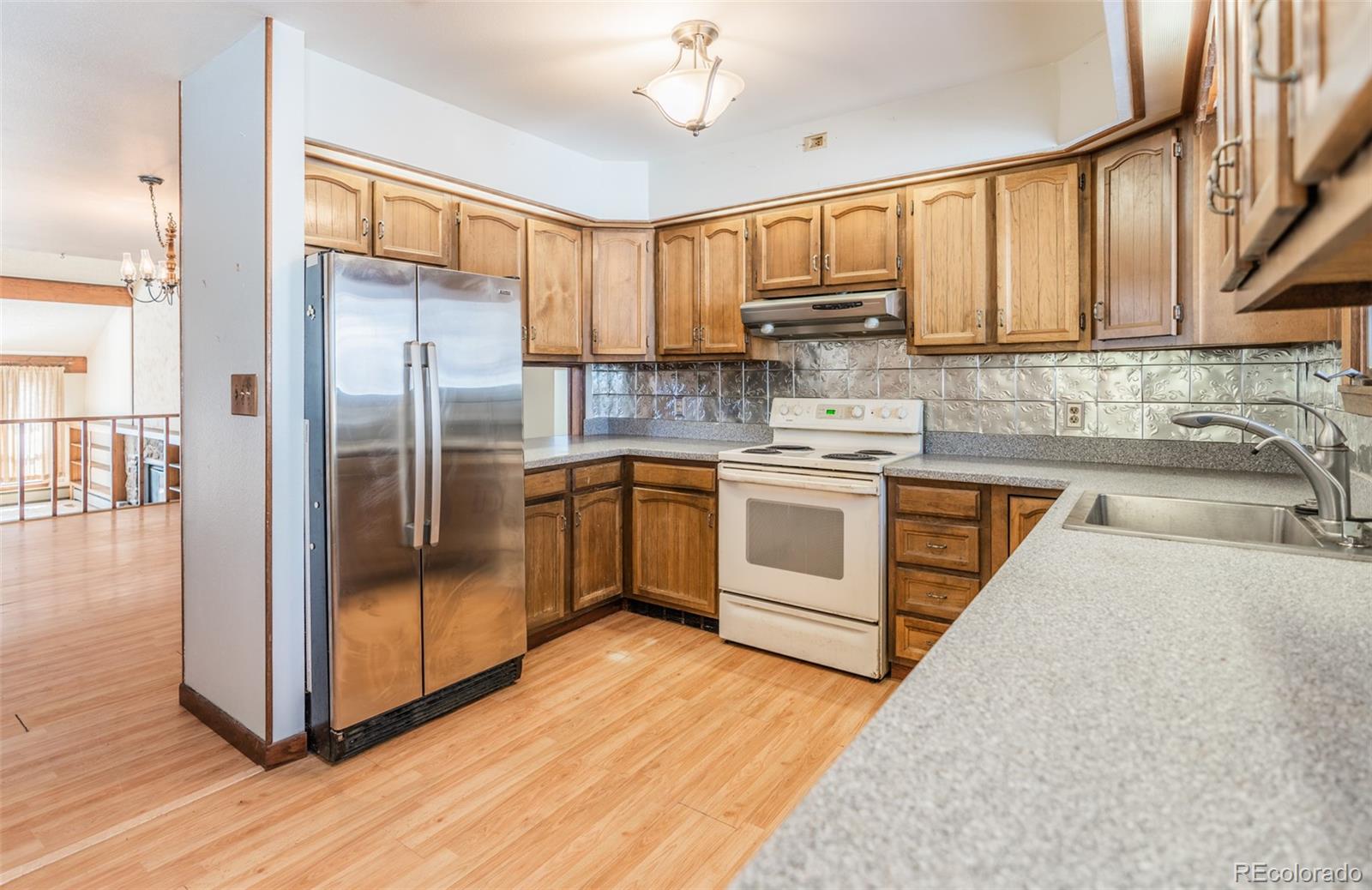 1189 Aspen Drive Evergreen, CO 80439 - Photo 8 of 37 a kitchen with wooden cabinets stainless steel appliances a sink and a window