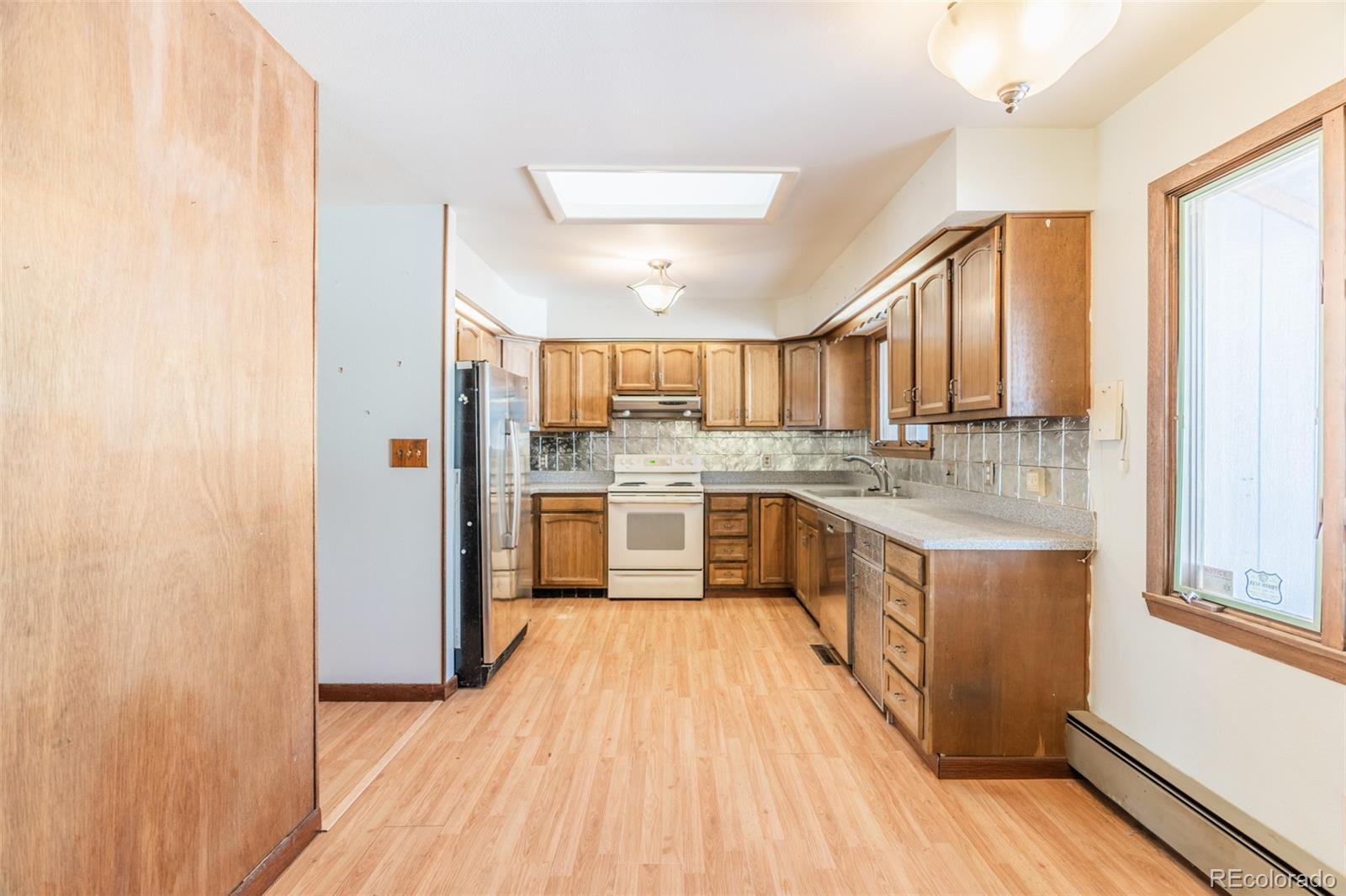 1189 Aspen Drive Evergreen, CO 80439 - Photo 9 of 37 a large kitchen with a sink and wooden floor